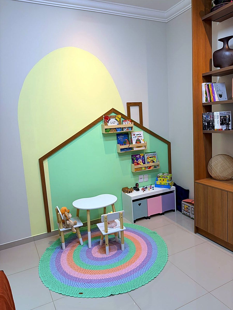 O cantinho das crianças no consultório da Casa Camomila, em Paragominas: casinha de madeira, livros e tapete colorido