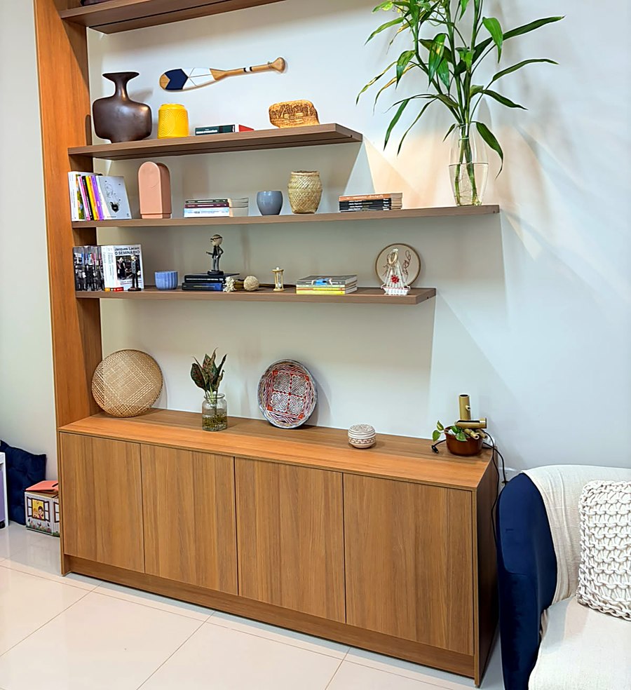 Estante do consultório da Casa Camomila, com livros, cerâmicas e plantas